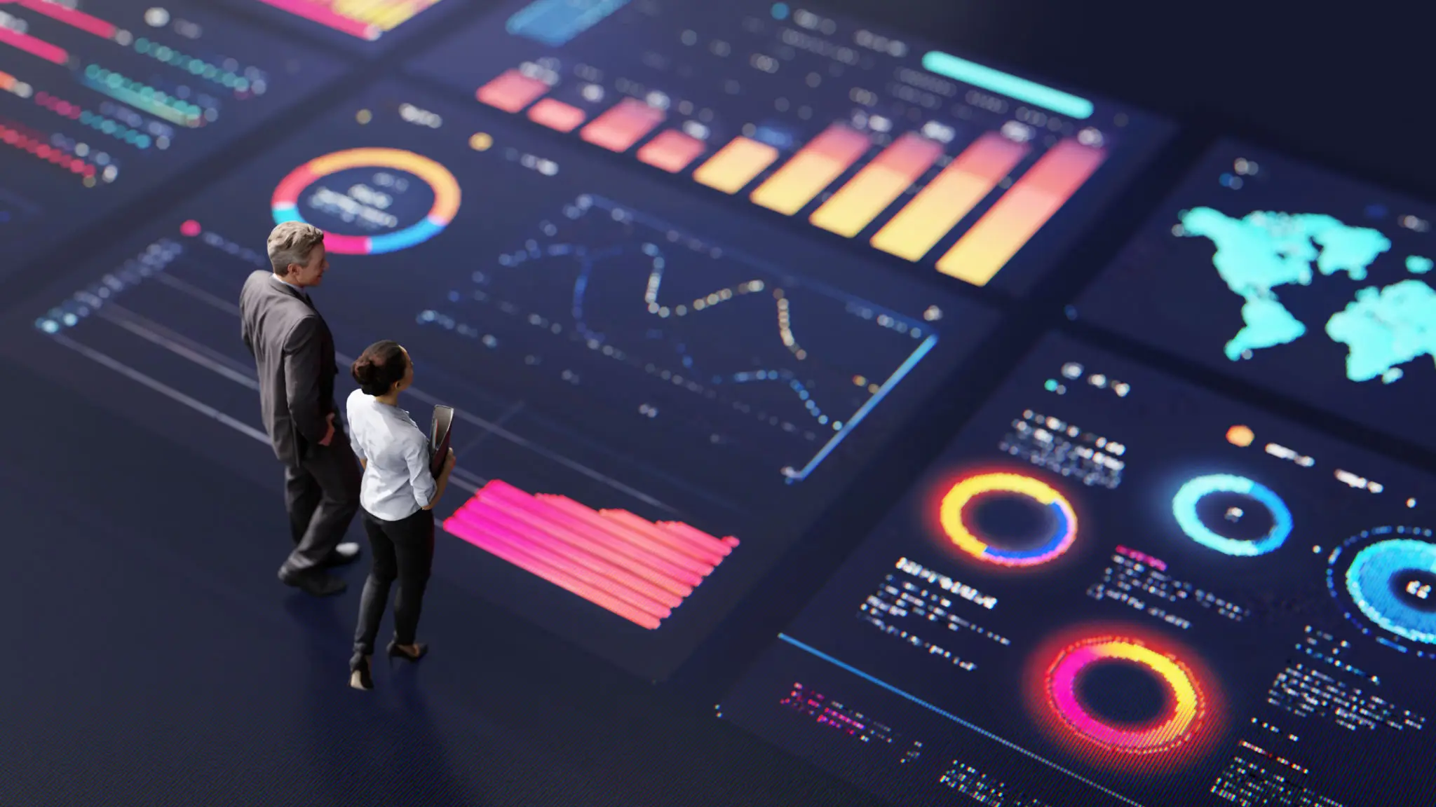 Two people analyze vibrant data visualizations on a large digital dashboard.